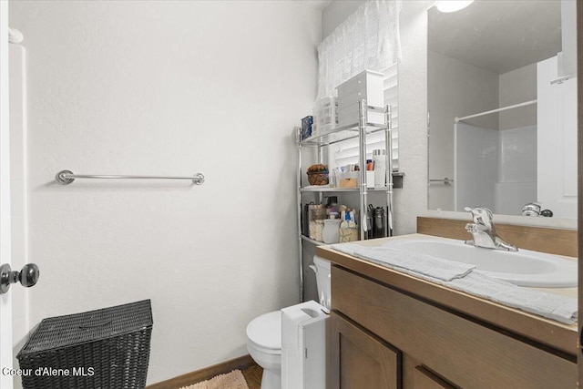 bathroom featuring a shower, vanity, and toilet