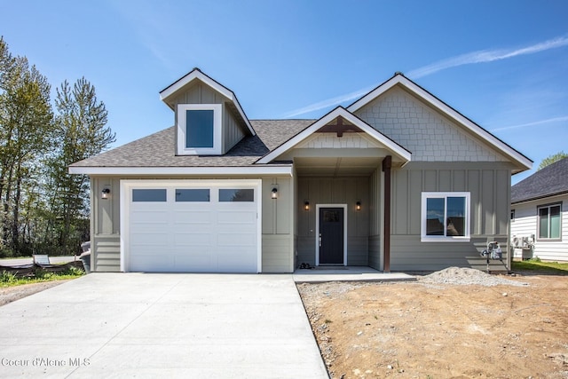 craftsman inspired home featuring roof with shingles, concrete driveway, an attached garage, and board and batten siding
