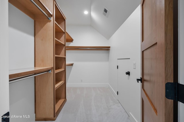 walk in closet featuring light colored carpet and lofted ceiling