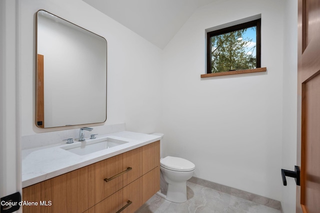 bathroom with tile patterned floors, vanity, toilet, and lofted ceiling