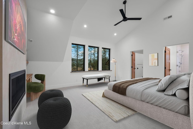 bedroom with ceiling fan, light carpet, high vaulted ceiling, and ensuite bath