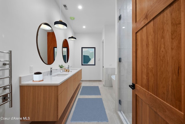 bathroom featuring hardwood / wood-style flooring, vanity, and walk in shower