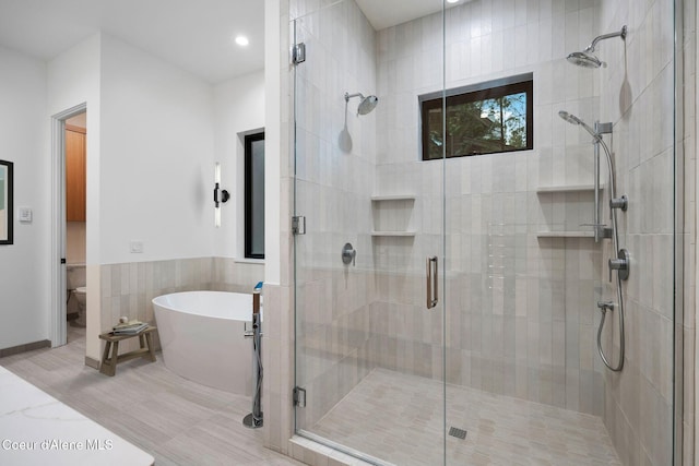 bathroom featuring separate shower and tub and toilet