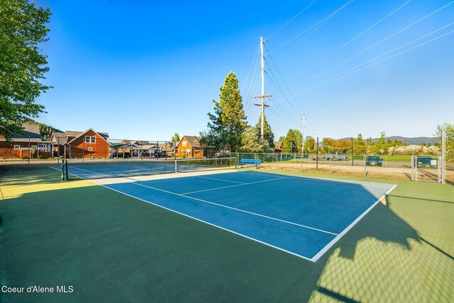 view of tennis court featuring basketball hoop