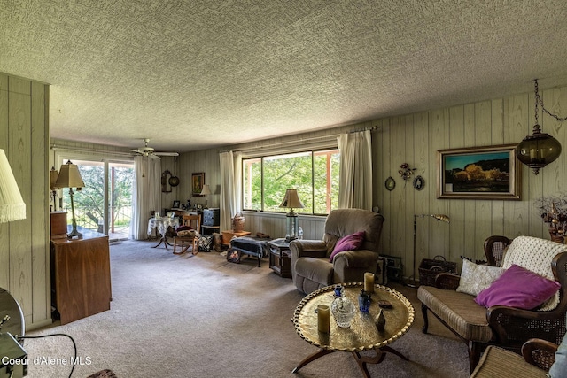 2834 W Conkling Rd, Worley, ID 83876 - living area with wooden walls, carpet floors, healthy amount of natural light, a textured ceiling, and a ceiling fan