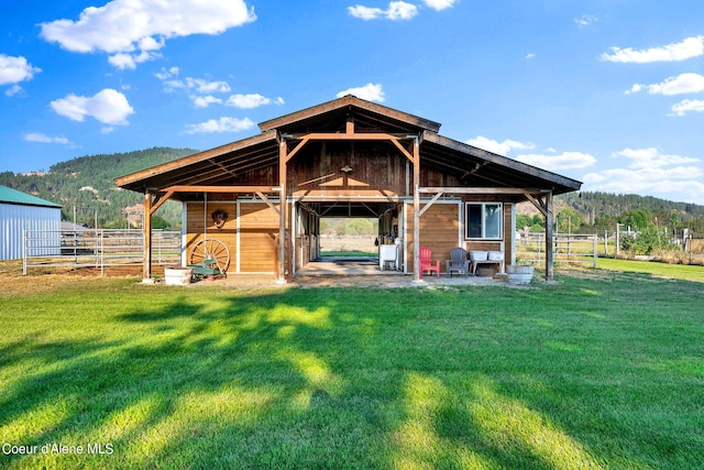 rear view of house featuring a mountain view and an outdoor structure