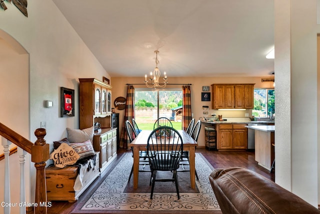 dining space with vaulted ceiling, dark hardwood / wood-style floors, and a notable chandelier