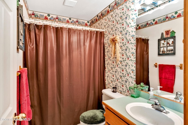 bathroom with curtained shower, vanity, and toilet