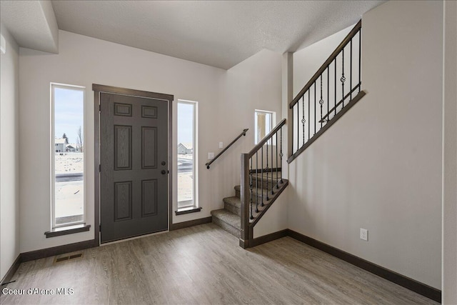 foyer with wood-type flooring and a textured ceiling