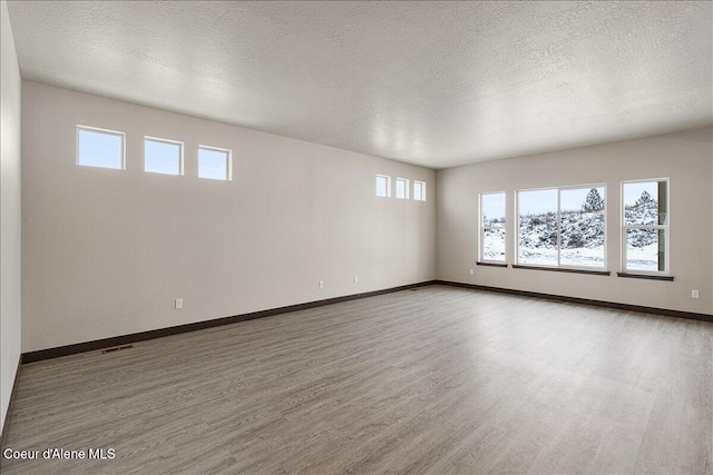 unfurnished room featuring hardwood / wood-style floors and a textured ceiling