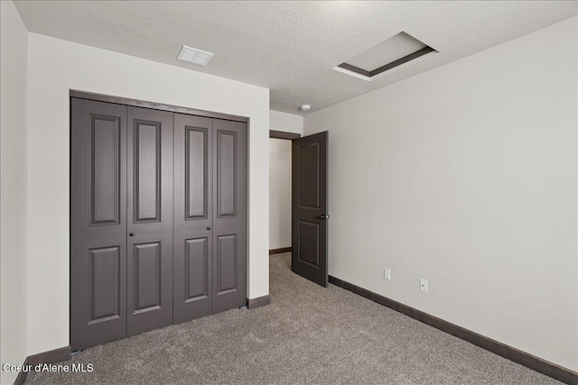 unfurnished bedroom featuring carpet, a textured ceiling, and a closet