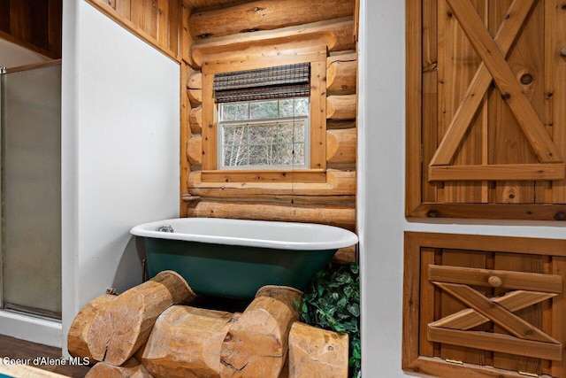 bathroom featuring a bathing tub and log walls