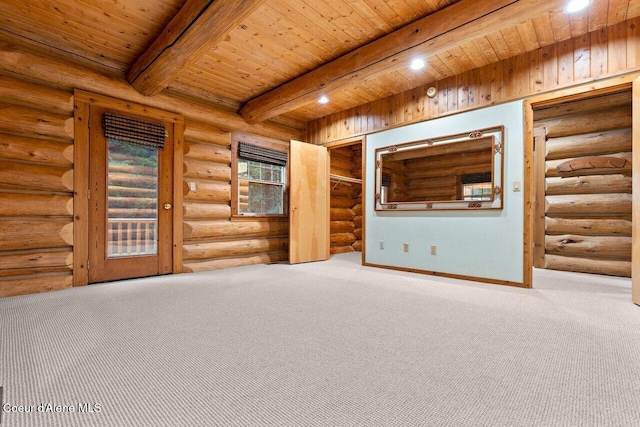 carpeted empty room with beam ceiling, rustic walls, and wood ceiling