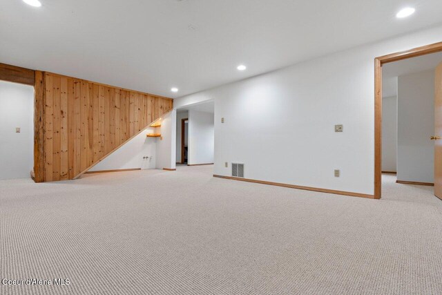 interior space with wood walls and light colored carpet