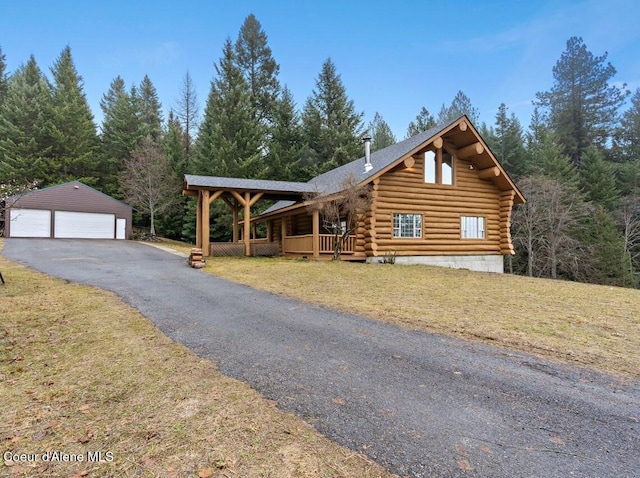 cabin featuring an outbuilding, a garage, and a front yard