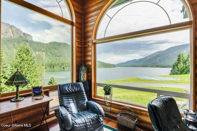 sunroom featuring plenty of natural light and a water and mountain view