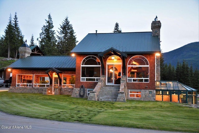 view of front of property featuring a mountain view, an outbuilding, and a front yard