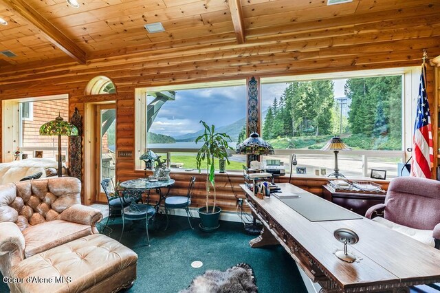 interior space with vaulted ceiling with beams, a mountain view, and wood ceiling