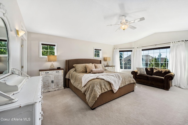 bedroom featuring light colored carpet, vaulted ceiling, and ceiling fan