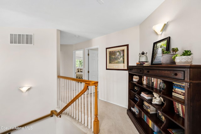 hall with light colored carpet