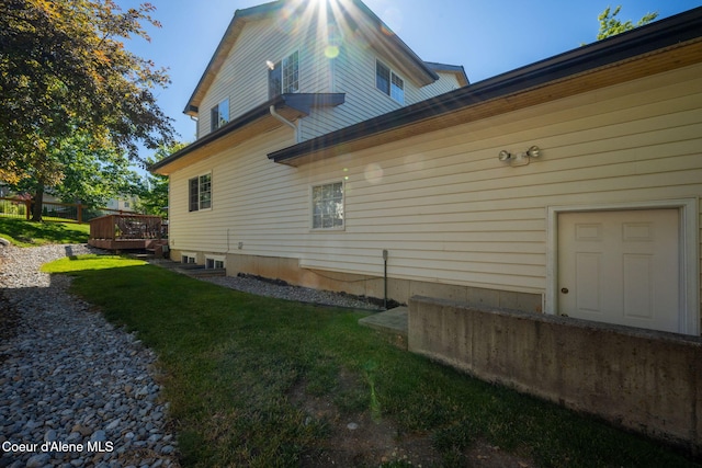 view of property exterior with a wooden deck and a yard