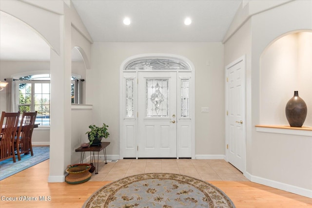 entrance foyer featuring baseboards, vaulted ceiling, wood finished floors, and recessed lighting