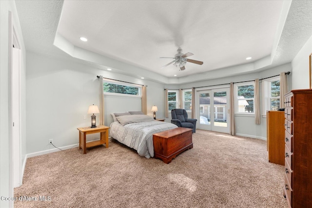 bedroom with carpet, a raised ceiling, and baseboards