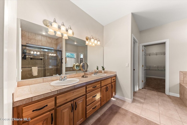 full bath with double vanity, tile patterned flooring, a sink, and a shower stall