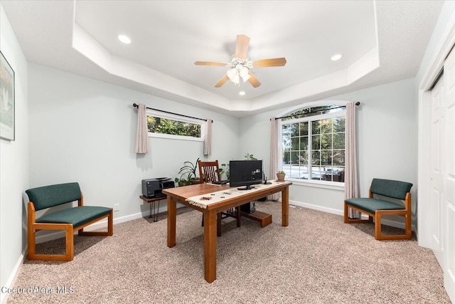 office featuring a tray ceiling, light colored carpet, baseboards, and recessed lighting