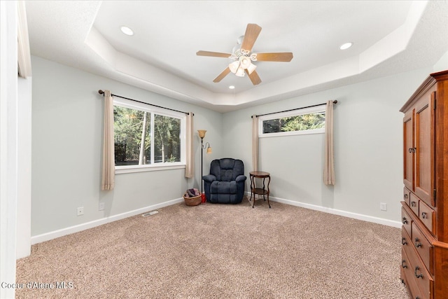 sitting room with carpet floors, a tray ceiling, baseboards, and recessed lighting