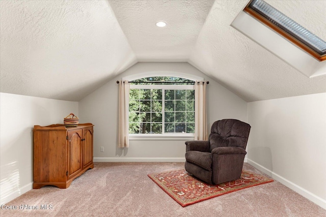 living area with vaulted ceiling, a textured ceiling, light carpet, and baseboards