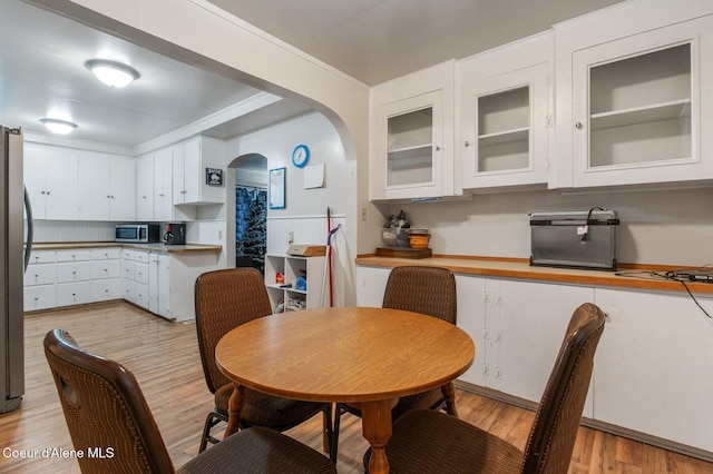 dining area featuring light hardwood / wood-style flooring and ornamental molding