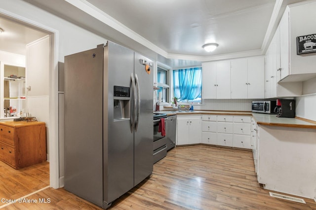 kitchen featuring white cabinets, light wood-type flooring, and stainless steel appliances