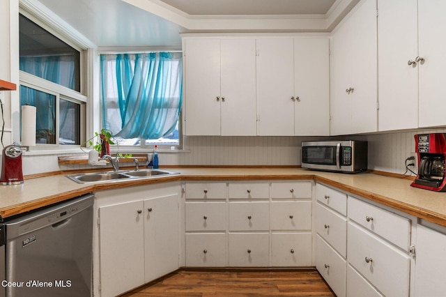 kitchen with dishwasher, hardwood / wood-style flooring, white cabinetry, and sink