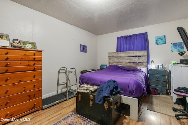 bedroom featuring a textured ceiling and light wood-type flooring