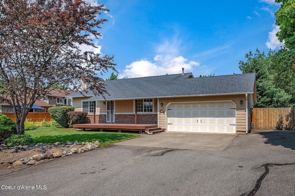 single story home with a garage and a front lawn