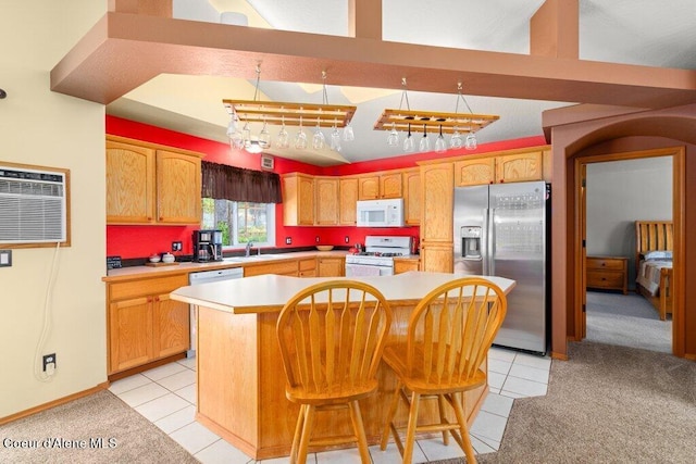 kitchen featuring white appliances, a kitchen breakfast bar, light tile patterned floors, a wall mounted AC, and a kitchen island