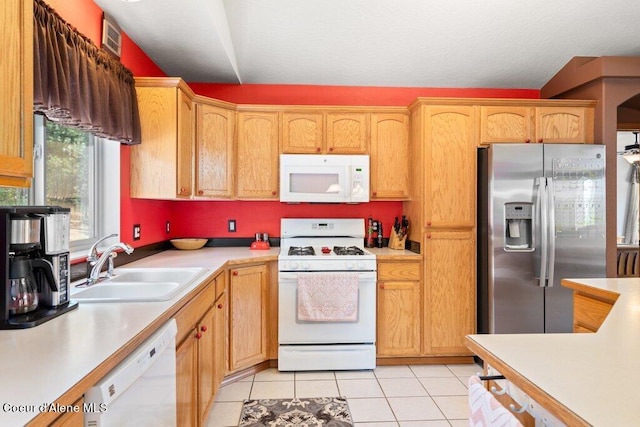 kitchen with sink, light tile patterned floors, and white appliances