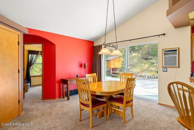 dining area featuring light colored carpet, lofted ceiling, and a wall mounted AC