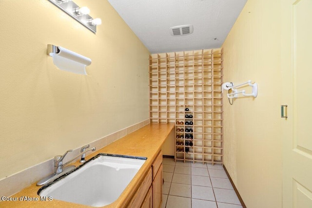 bathroom with tile patterned flooring, sink, and a textured ceiling