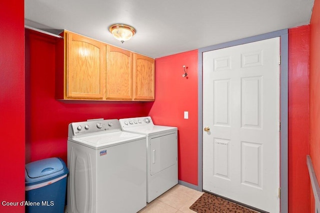 washroom with cabinets, light tile patterned floors, and washer and dryer