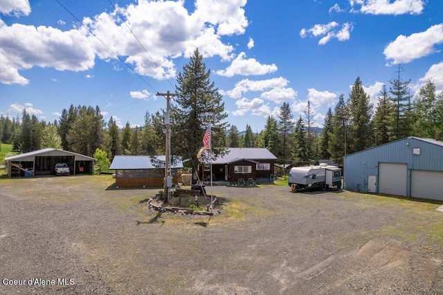 view of front of house with a carport, a garage, and an outdoor structure