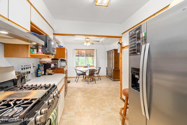 kitchen featuring stainless steel appliances, white cabinetry, and ceiling fan