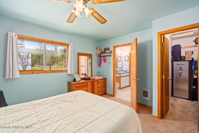 bedroom with connected bathroom, ceiling fan, and light colored carpet