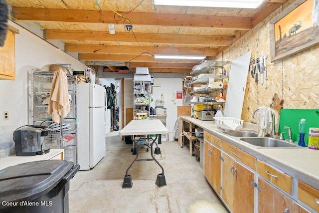 kitchen with sink, white fridge, and beamed ceiling