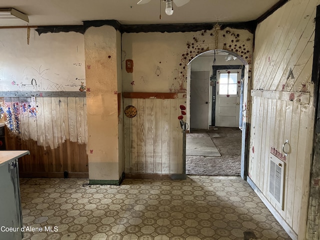 miscellaneous room with ceiling fan and wood walls