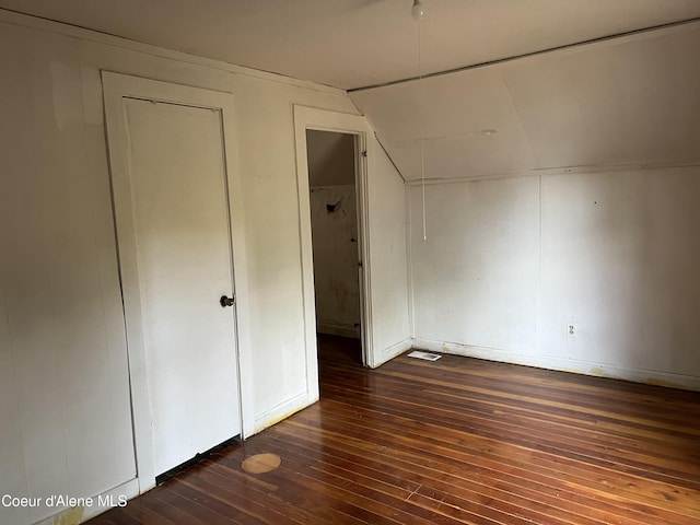 unfurnished bedroom featuring dark hardwood / wood-style flooring and lofted ceiling