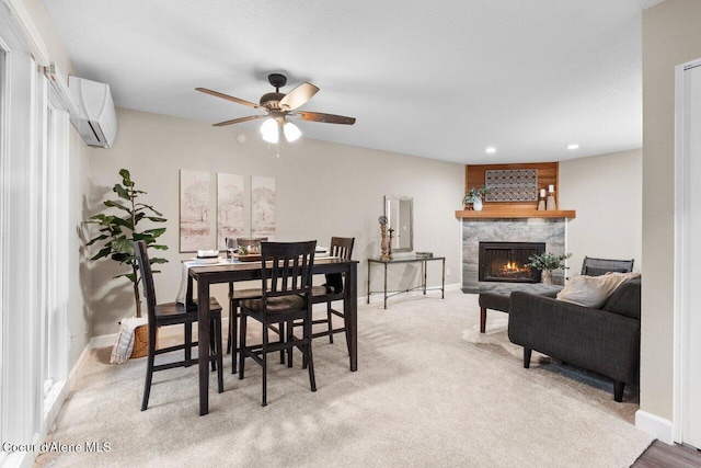 carpeted dining room featuring ceiling fan, a premium fireplace, and a wall mounted AC