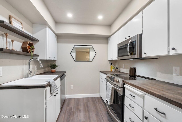 kitchen featuring hardwood / wood-style flooring, sink, white cabinets, and appliances with stainless steel finishes