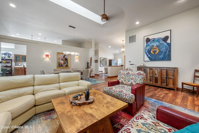 living room featuring vaulted ceiling, ceiling fan, and dark wood-type flooring